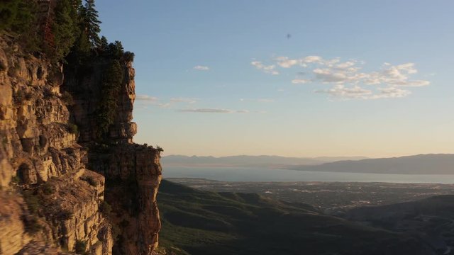 Flying near a mountain cliff showing Utah Lake near Provo, Utah.