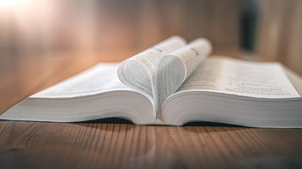 Opening holy Bible in morning on wooden table. christian oncept.