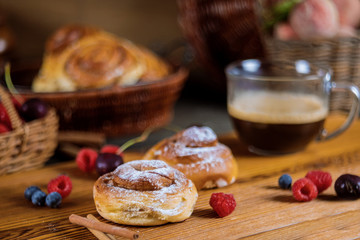 Homemade delicious cinnamon rolls with coffee and cinnamon sticks selective focus