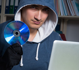 Young hacker hacking into computer at night