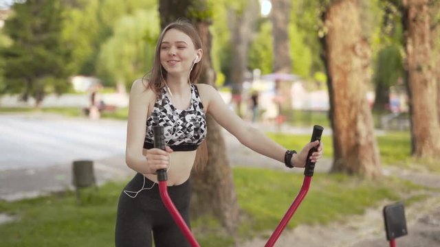 Happy fit life Polish woman exercising on a cross trainer, medium shot