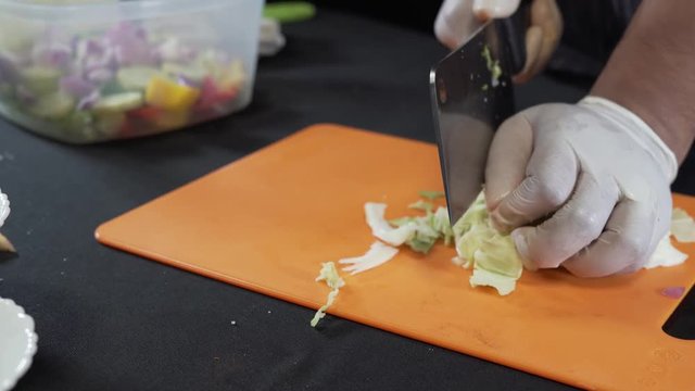 A chef carefully makes a cabbage into slices with the help of a knife. Keto diet food