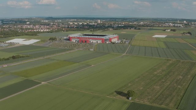 Drone / Aerial shot of the football stadium of the bundesliga team FSV Mainz 05 with field in the foreground on a sunny day, 25p