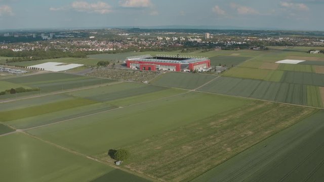 Drone / Aerial shot of the football stadium of the bundesliga team FSV Mainz 05 with field in the foreground on a sunny day, 30p