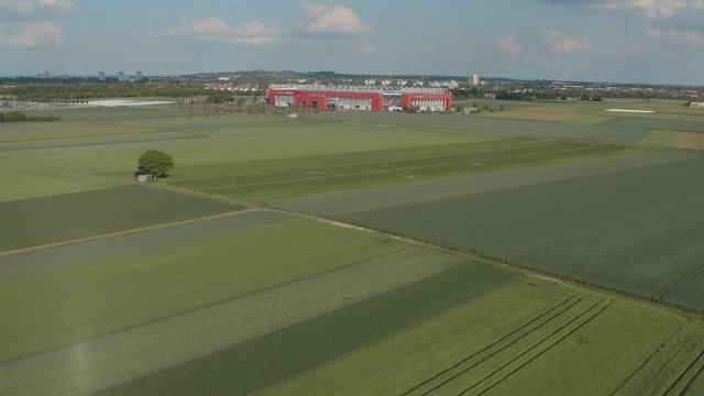 Drone / Aerial shot of the football stadium of the bundesliga team Mainz 05 with field in the foreground on a sunny day, 25p
