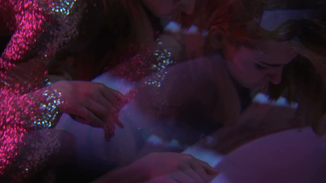 Intoxicated young woman vomiting in night club toilet, binge drinking at party