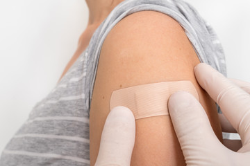 Woman with adhesive bandage on her shoulder