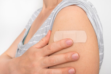 Woman with adhesive bandage on her shoulder