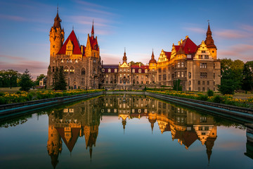 Castle in Moszna during the sunrise,. reflecting in the fountain. Opole, Silesia, Poland. - obrazy, fototapety, plakaty