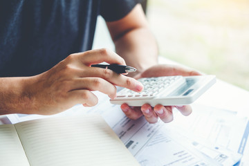 Man using calculator Accounting Calculating Cost Economic bills with money stack step growing...