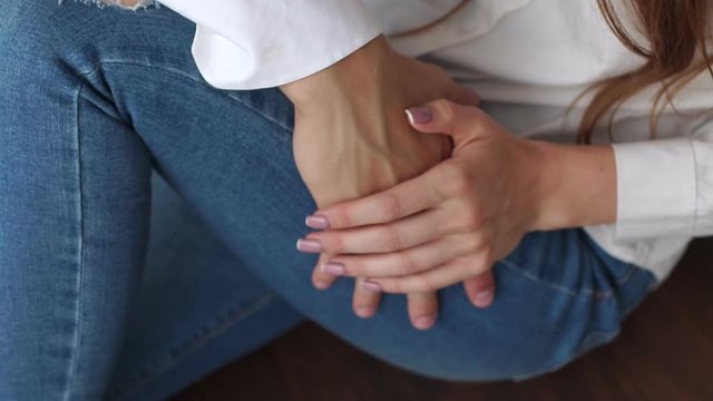 Close-up of a guy touching the leg of his favorite girl in jeans lying on the bed, sexual romantic relationship. Passionate couple on the bed in the morning, close-up. Slow motion.
