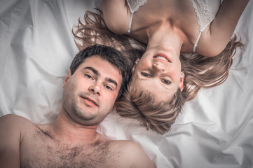 Top view of loving couple lying together in bed