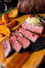 rustic medium butter beef steak with herbs and potato wedges