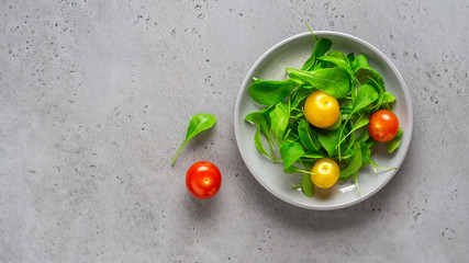 Healthy vegetable salad of fresh arugula and colorful tomatoes. Health care, detox, fitness, diet concept.