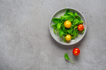 Healthy vegetable salad of fresh arugula and colorful tomatoes. Health care, detox, fitness, diet concept.
