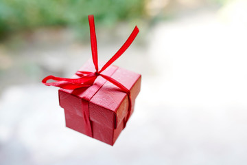 red gift box on light background with copy space, surprise for birthday or valentine's day
