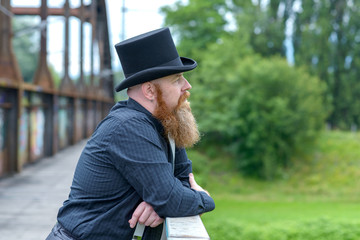 Bearded man in a top hat lost in deep thought
