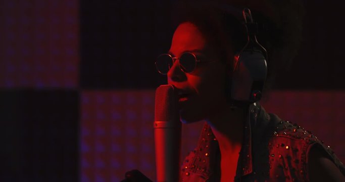Woman singing in recording booth