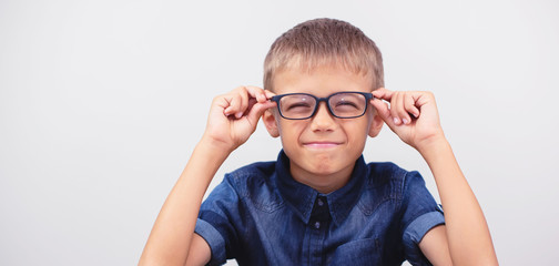 Banner little boy with glasses correcting myopia close-up portrait Ophthalmology problem selective...