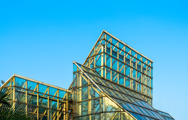 Green House with Glass Roof Over The Clear Blue Sky. Turquoise Shade Glass Transparent Building 