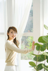 カーテンを開ける女性