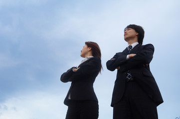 腕組みするビジネスマンとビジネスウーマン