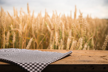 wood board table in front of field of wheat on sunset light. Ready for product display montage