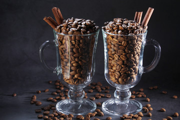 Two glasses full of coffee beans with cinnamon as a concept of coffee drinking	