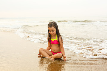 Fototapeta na wymiar Happy girl on a tropical beach ocean has a fun with splash