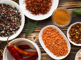 Group of bowls full of spices on wooden background