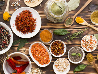 Group of bowls full of spices on wooden background