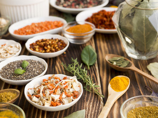 Group of bowls full of spices on wooden background