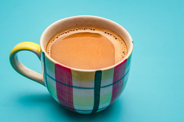 A cup of coffee on blue desk.
