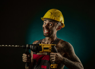 A man miner in a worker s clothes and a helmet, dirty, in soot, with a naked body, grimaces at the...