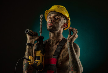 A man miner in a worker s clothes and a helmet, dirty, in soot, with a naked body, grimaces at the...
