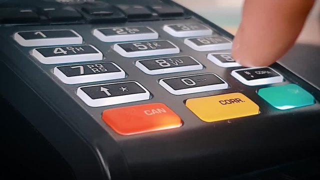 Entering number 1859 on pos terminal for a purchase contactless payment. A man hand enters a pin code on the Point Of Sale pos terminal.