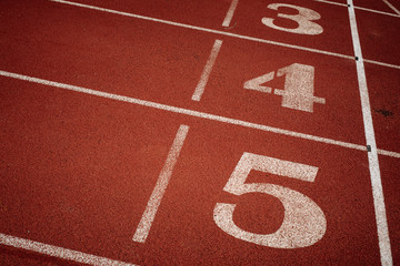 Sport. A red treadmill or athletics track with numner of line at the stadium. Copy space