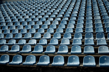 Rows of blue empty seats in the stand in the sports arena.