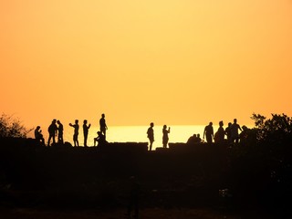 Fototapeta na wymiar beautiful human silhouettes during the golden hour at Fort, Agoda, Goa