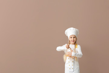 Cute little chef on color background