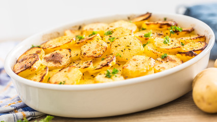Roasted potatoes with spices and herbs on kitchen table