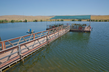 Fototapeta premium Landscape of an mountain lake in front of mountain range. Glorious lake landscape. The collaboration of blue and green. Restaurant and bridge in the middle of the lake . View of Abant Lake Golu .