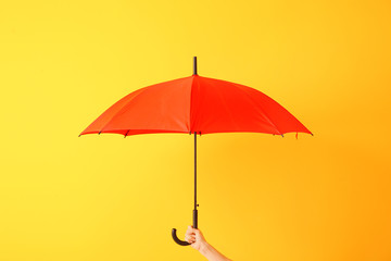 Fototapeta na wymiar Female hand with stylish umbrella on color background