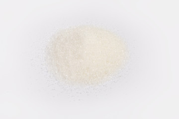 Fototapeta na wymiar Handful of the white sugar on a light colored surface