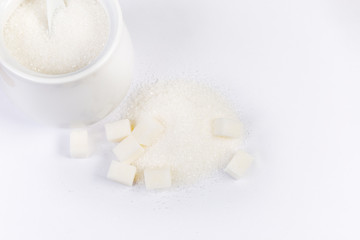 Fototapeta na wymiar Sugar on pile with sugar cubes and in sugar-bowl