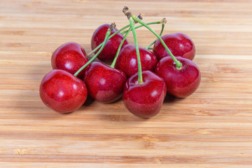 Red sweet cherries with stalks on a wooden surface