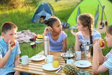 Group of children having picnic outdoors on summer day