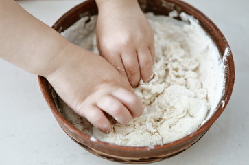 baby hands knead the dough in a pizza plate