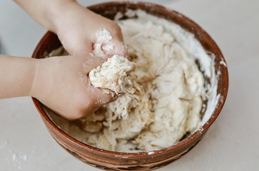 baby hands knead the dough in a pizza plate