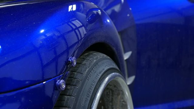The car automatically falls on the wheel. Blue automobile tuning wheel